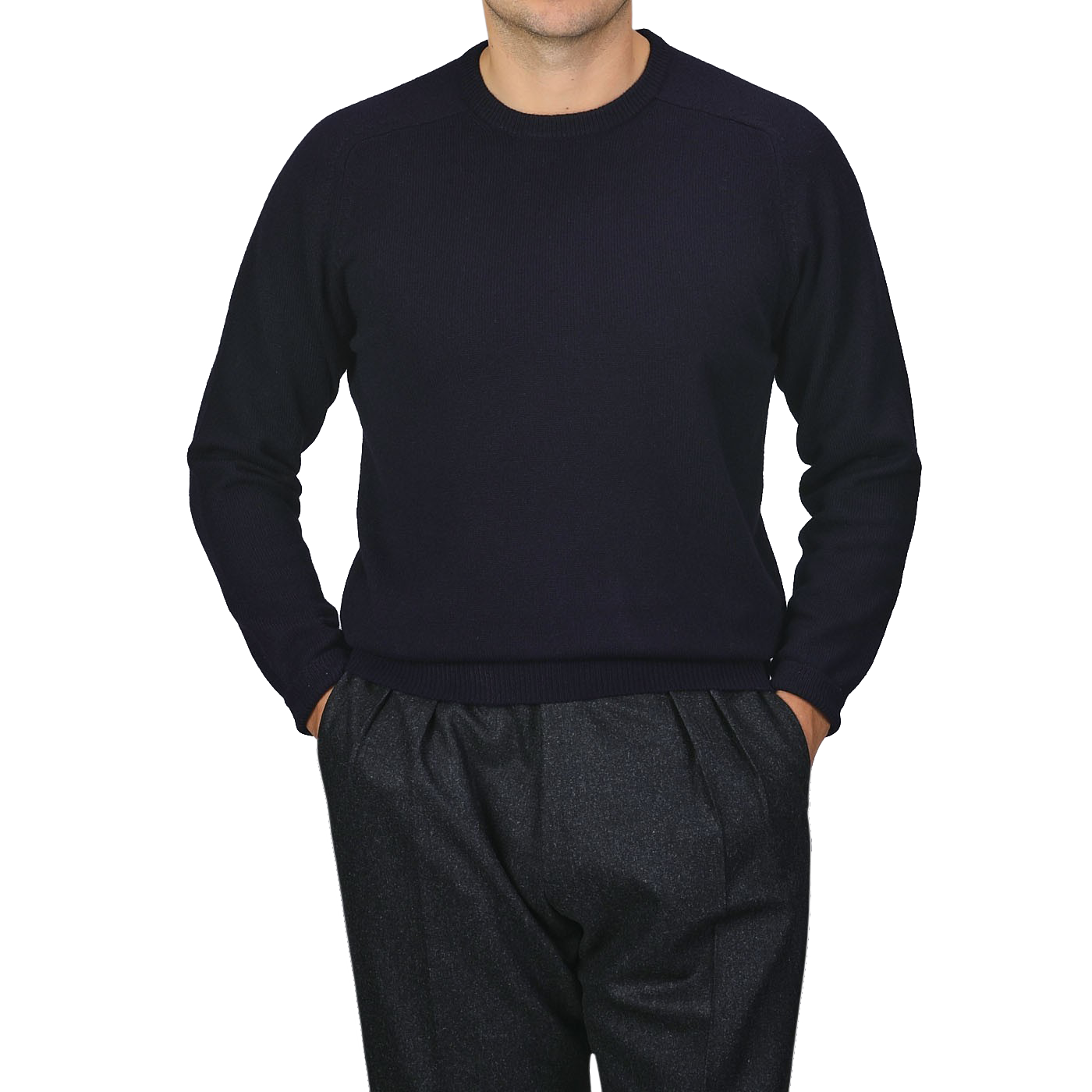 A person wearing an Alan Paine Navy Blue Lambswool Crew Neck sweater and dark gray trousers, with hands in pockets, standing against a plain gray background.