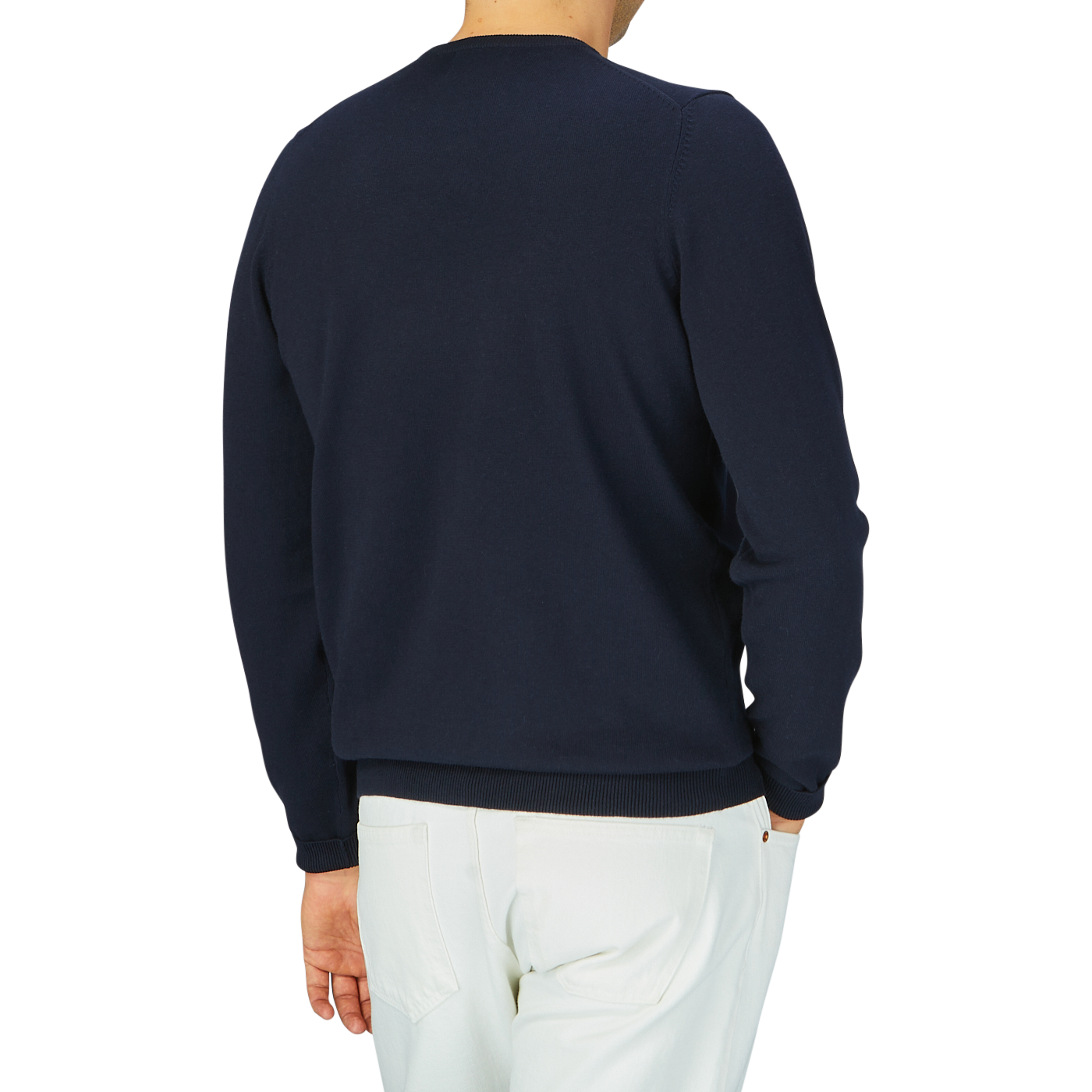 Man wearing an Alan Paine navy blue luxury cotton crewneck sweater and white pants, viewed from behind.