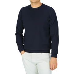 Man wearing an Alan Paine Navy Blue Luxury Cotton Crewneck sweater and white pants against a gray background.