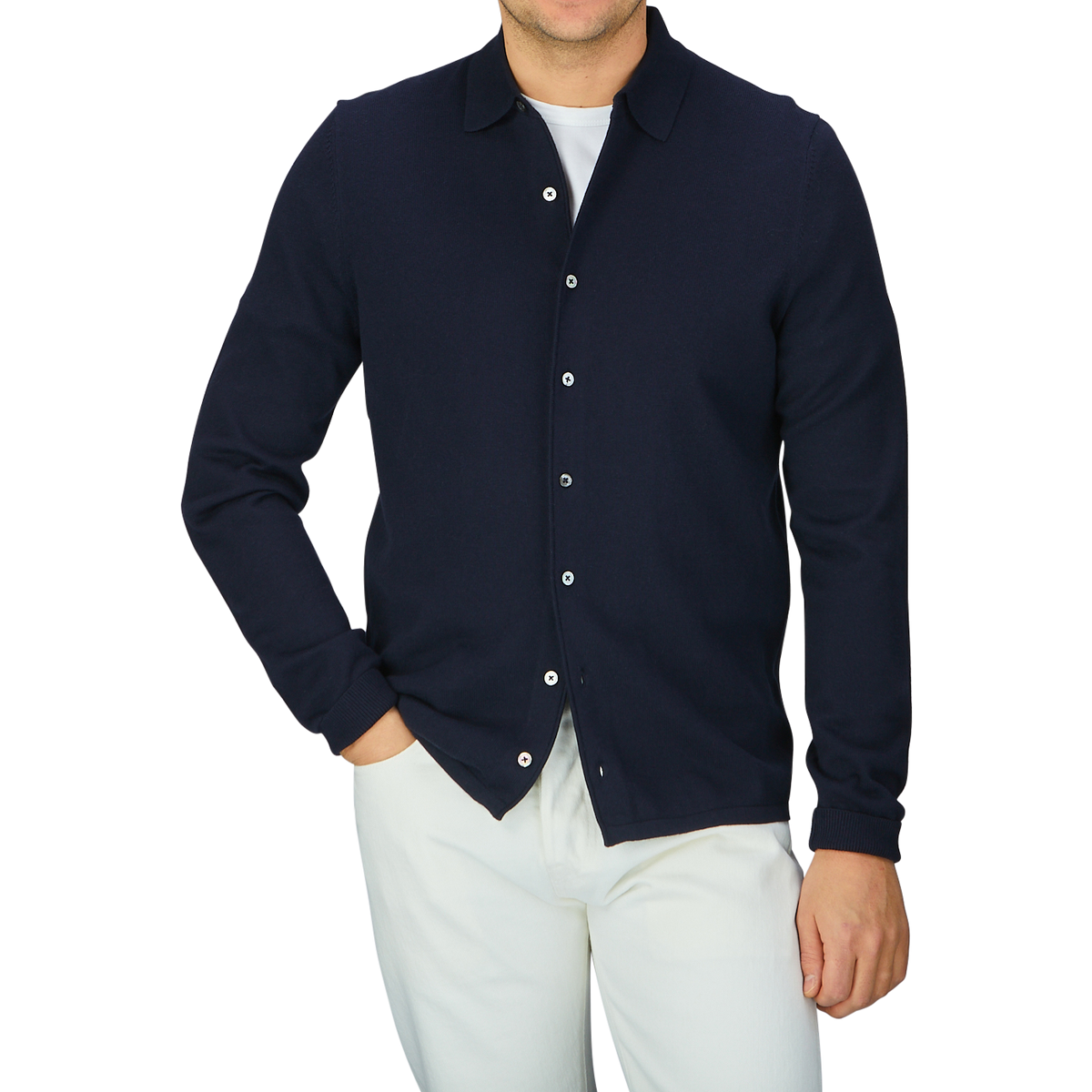 A man wearing a navy blue Alan Paine Luxury Cotton Knitted Overshirt and white pants.