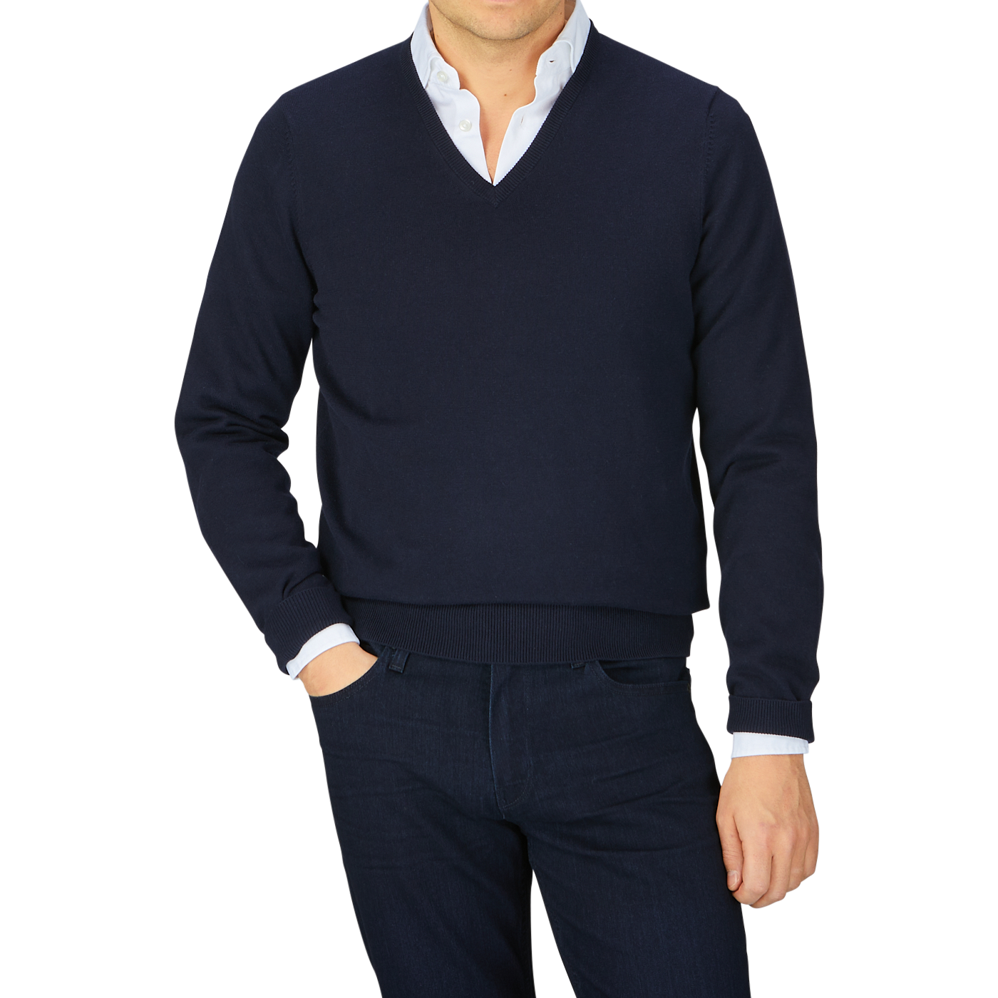 Man wearing a Navy Blue Luxury Cotton V-Neck Sweater by Alan Paine over a white shirt with dark trousers against a grey background.