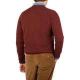The back view of a man wearing an Alan Paine Nebula Red Brown Lambswool V-Neck sweater.