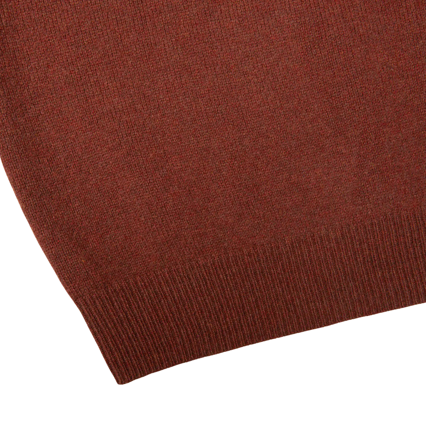 Close-up of the corner of the Nebula Red Brown Lambswool V-Neck, featuring a ribbed hem detail, reminiscent of an Alan Paine sweater.