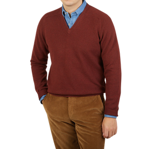 A man wearing a maroon Alan Paine Nebula Red Brown Lambswool V-Neck sweater.