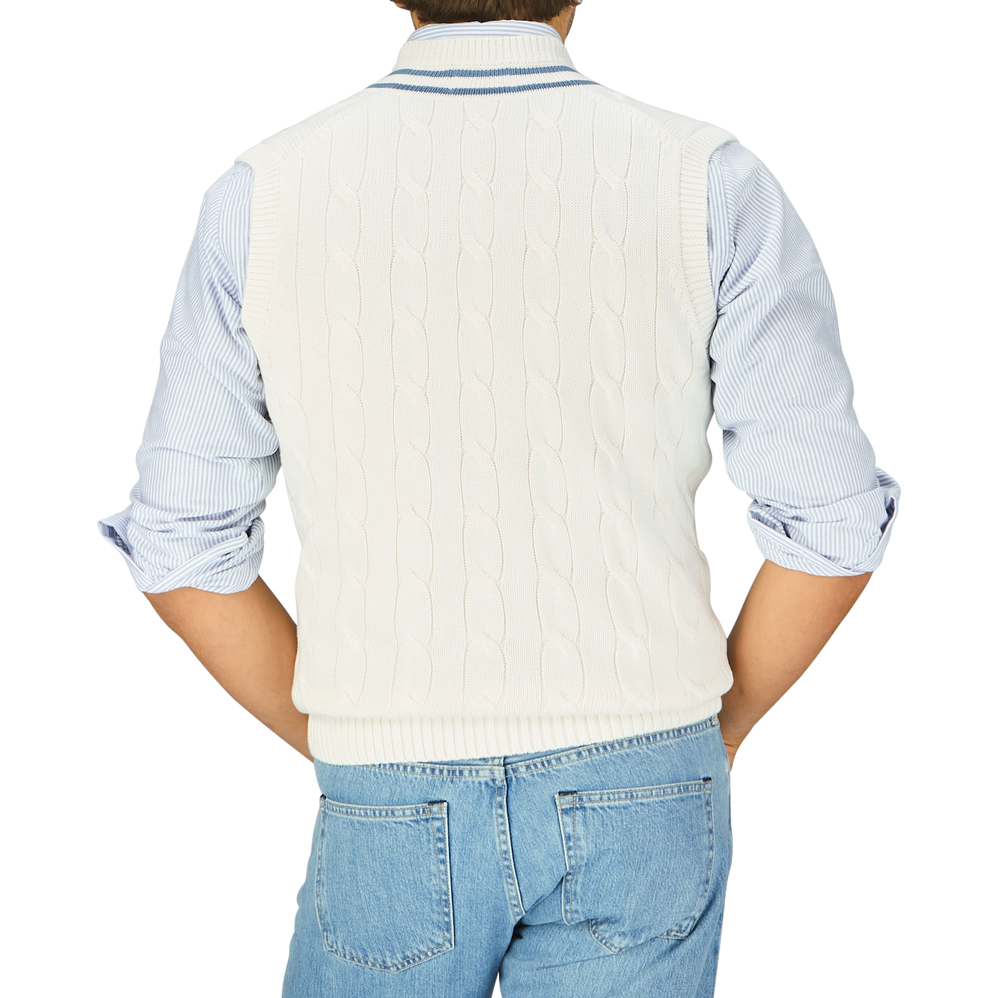 Person wearing an Off-White Blue Striped Cotton Cricket Slipover by Alan Paine over a blue and white striped shirt, paired with denim jeans, viewed from the back.