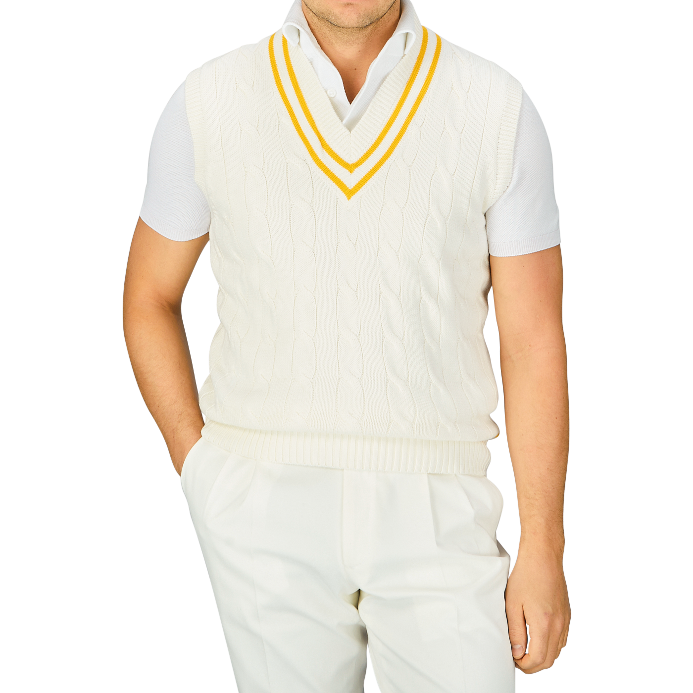 Man wearing an Alan Paine Off-White Yellow Striped Cotton Cricket Slipover with yellow and blue trim over a collared shirt, and white pants.