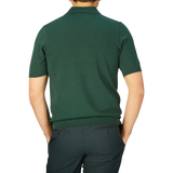 A person seen from behind wearing a Racing Green Knitted Cotton Polo Shirt from Alan Paine and grey trousers.