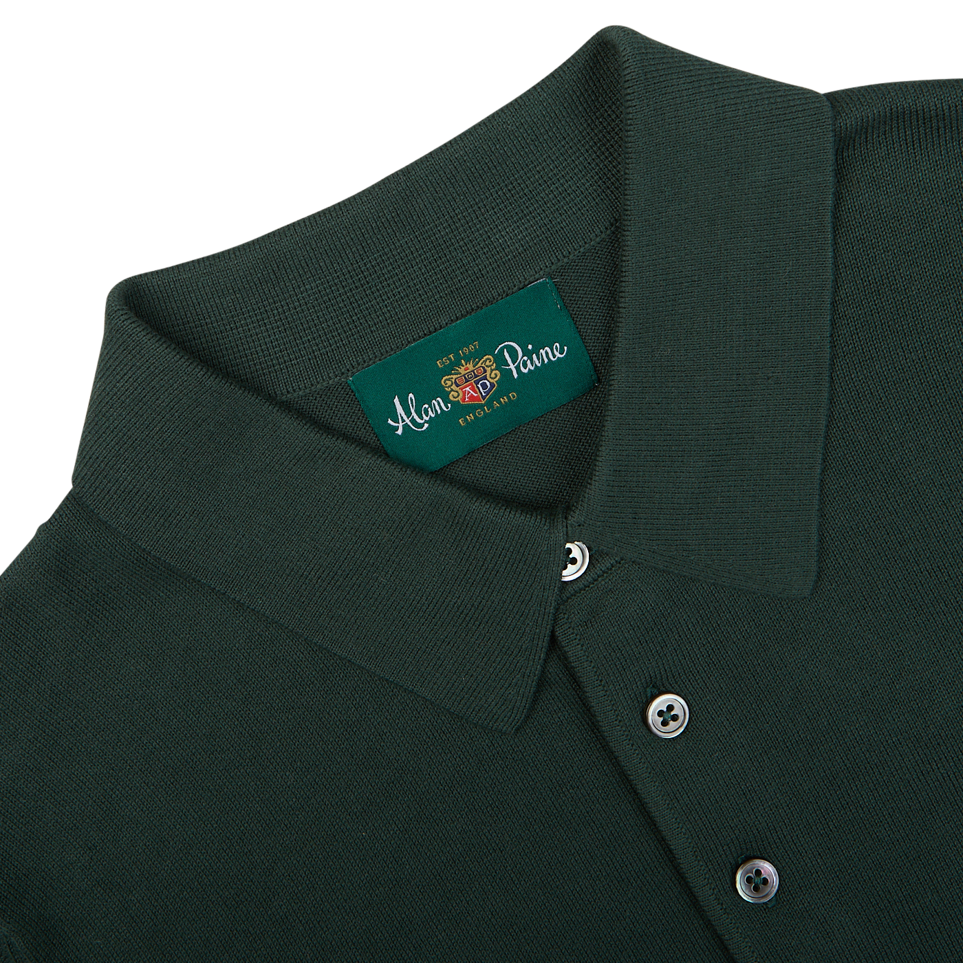 Close-up of a racing green Alan Paine Knitted Cotton Polo Shirt with a collar and buttons, displaying a brand label.