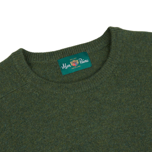 An Alan Paine crew neck sweater in rosemary green, made of lambswool.