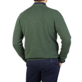 The contemporary back view of a man wearing an Alan Paine Rosemary Green Lambswool V-Neck sweater.