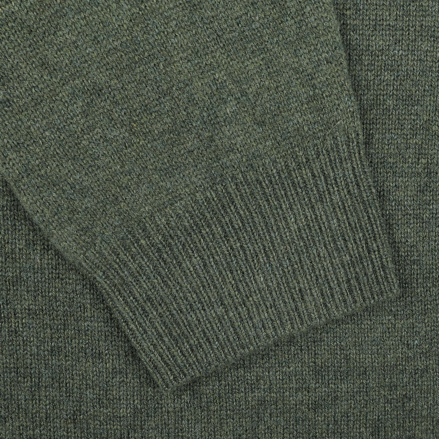 Close-up of a sleeve from the Alan Paine Rosemary Green Lambswool V-Neck, highlighting the ribbed cuff texture crafted from soft Australian lambswool.