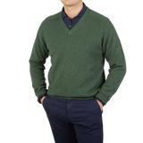 A contemporary man wearing an Alan Paine Rosemary Green Lambswool V-Neck sweater.