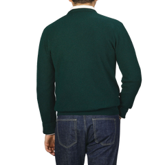 Back view of a person wearing an Alan Paine Tartan Green Lambswool Crew Neck sweater and blue denim jeans, standing against a plain background.