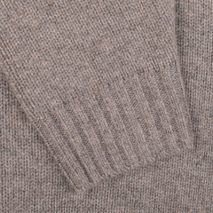 Close-up of a taupe beige knitted fabric with ribbed detailing, reminiscent of an Alan Paine Landford lambswool cardigan.