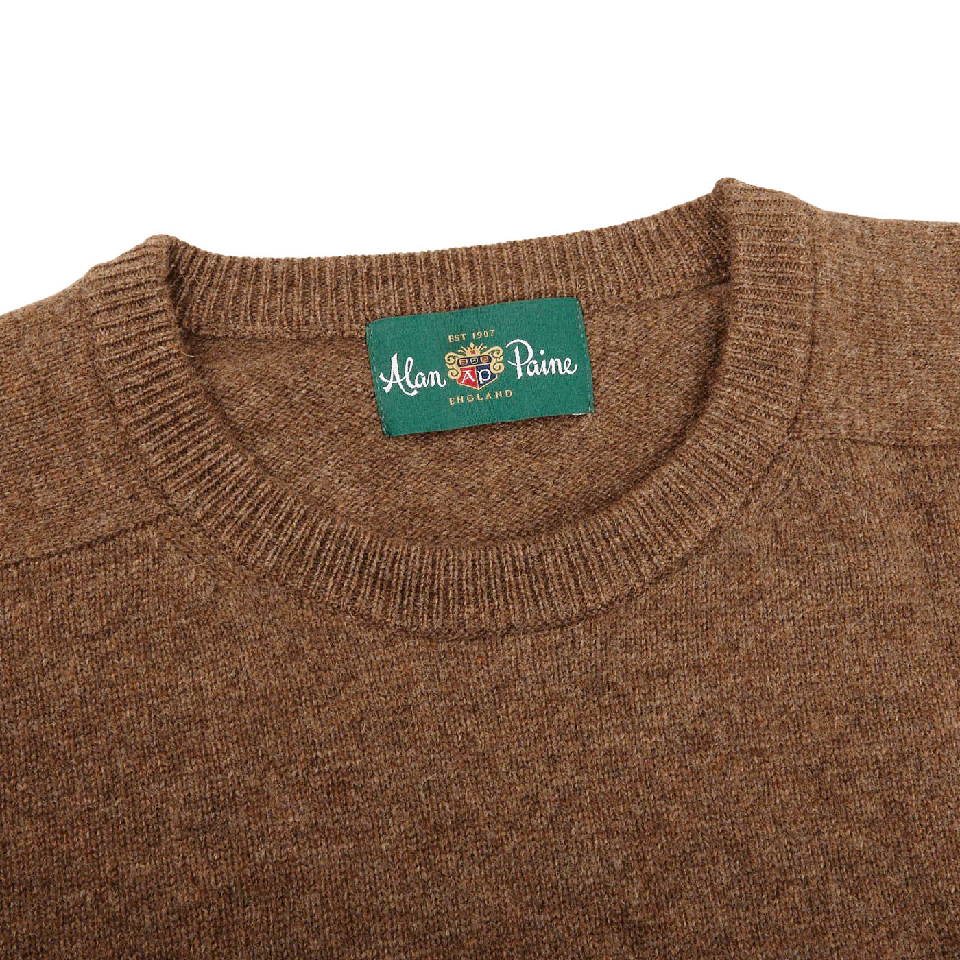 Introducing the Tobacco Brown Lambswool Crew Neck by Alan Paine— a luxurious Australian lambswool sweater featuring a green label on the inside that reads "Alan Paine England." The saddle shoulder design adds a touch of sophistication to this timeless piece.