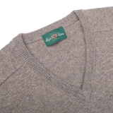 The Vole Beige Lambswool V-Neck, crafted from Australian lambswool, features an updated fit and a green label that reads "Alan Paine" and "EST 1907.