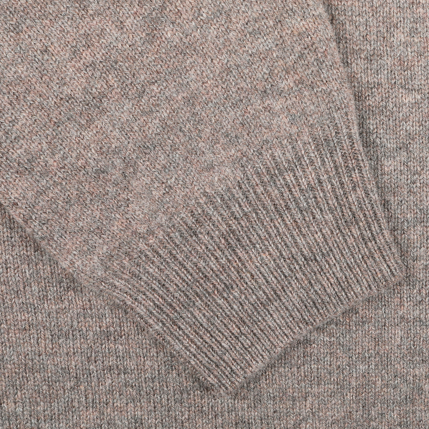 Close-up image of a beige knitted fabric with a visible sleeve cuff detail, showcasing the updated fit of the Alan Paine Vole Beige Lambswool V-Neck sweater made from luxurious Australian lambswool.