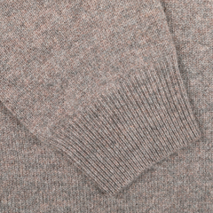 Close-up image of a beige knitted fabric with a visible sleeve cuff detail, showcasing the updated fit of the Alan Paine Vole Beige Lambswool V-Neck sweater made from luxurious Australian lambswool.