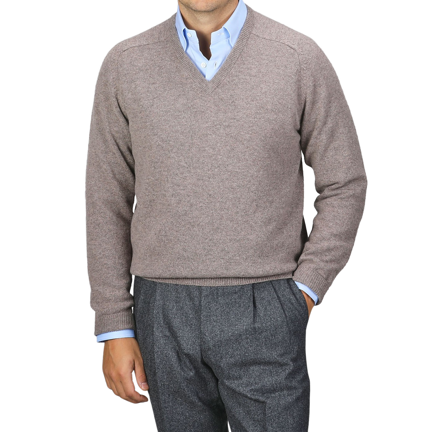 A person wearing an Alan Paine Vole Beige Lambswool V-Neck sweater over a blue dress shirt with updated fit gray trousers stands against a plain background.