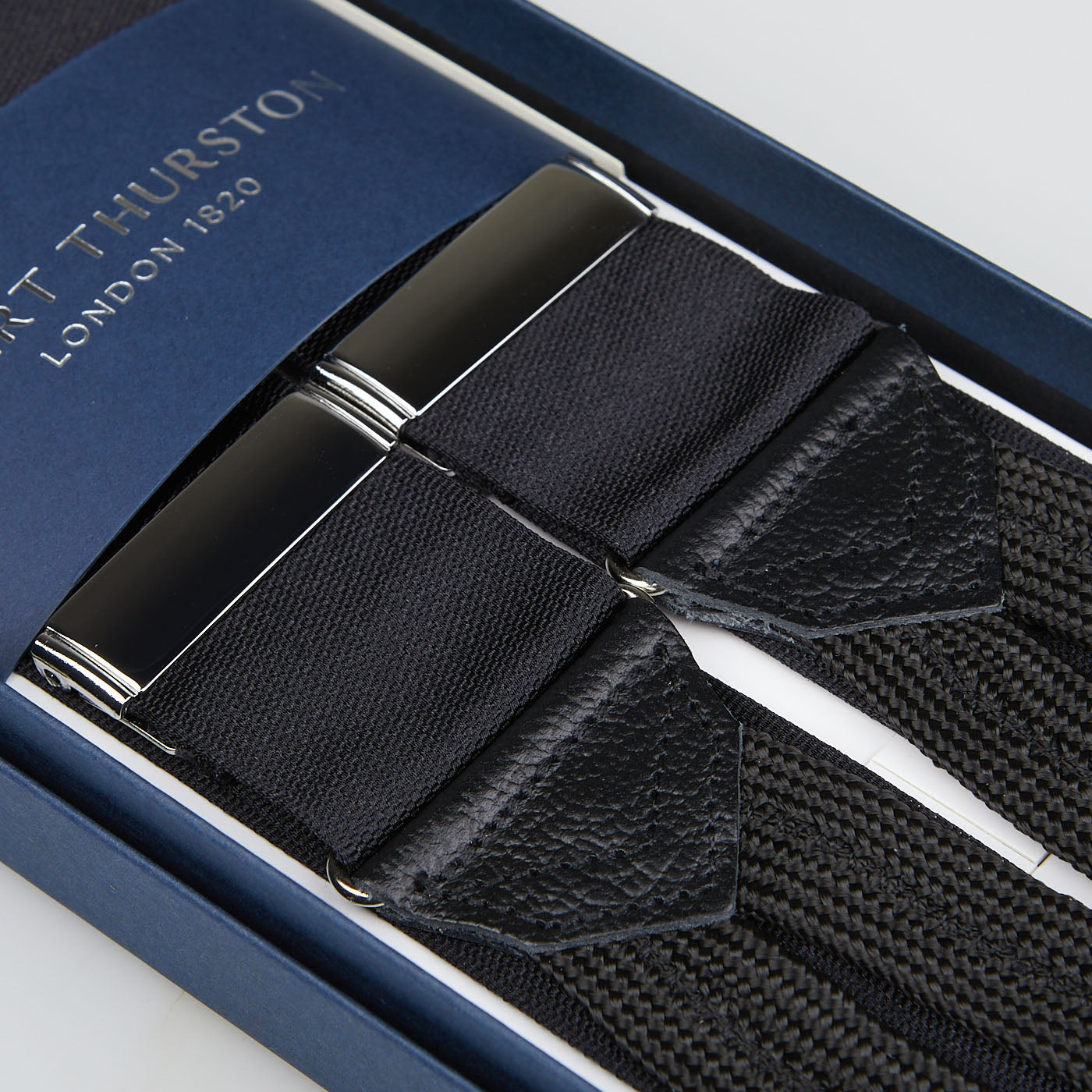 Black Nylon Leather 40mm Braces with silver clips, crafted by British craftsmen, displayed in an open blue box labeled "Albert Thurston London 1820.