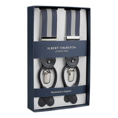 This set of Albert Thurston's Blue Grey Striped Nylon 35 mm Braces features a stylish combination of blue and gray stripes, complemented by black leather accents and silver clasps. Expertly crafted from premium materials, these braces proudly bear the label "Handmade in England.