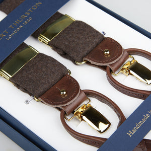 Four brown leather and grey wool flannel suspenders with gold-tone clasps, displayed in a blue box labeled "handmade in London" have been replaced by four Brown Wool Flannel 35 mm Braces by Albert Thurston.