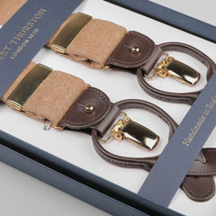 Close-up of a boxed pair of Albert Thurston Camel Beige Wool Flannel 35 mm braces, showcasing gold-tone clips and leather details, labeled "Handmade in England.