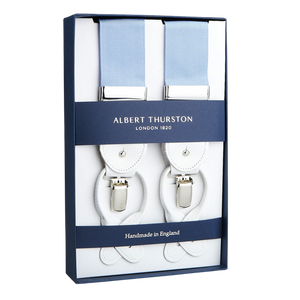 A pair of Albert Thurston Crayon Blue Nylon White Leather 40 mm braces displayed in a box, indicating they are crafted from stretchable nylon fabric in England.