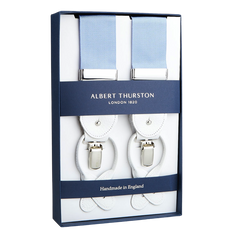 A pair of Albert Thurston Crayon Blue Nylon White Leather 40 mm braces displayed in a box, indicating they are crafted from stretchable nylon fabric in England.