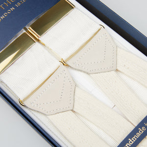 A pair of Cream Moiré 38 mm Albert Thurston braces, elegantly presented in a box. Perfect for adding a touch of class to any black-tie party attire. Elevate your style.