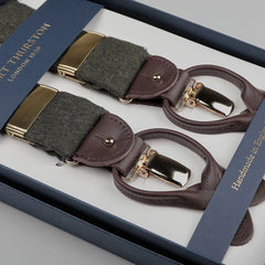 A set of handmade braces called "Moss Green Wool Flannel 35 mm Braces" from the brand Albert Thurston, featuring leather and fabric suspenders with adjustable lengths and gold-colored clasps, packaged in a box.