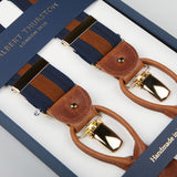 Close-up image of Albert Thurston branded Navy Brown Striped Nylon Leather 35 mm Braces in a box. The handmade suspenders are navy blue with brown stripes, featuring leather and gold-tone metal fastenings. "Handmade in England" is engraved on the box, highlighting the British brand's commitment to quality.