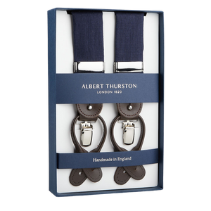 A pair of Albert Thurston Navy Linen and Brown Leather 35 mm Braces in a presentation box, featuring navy straps and leather fittings, with the text "Handmade in England.