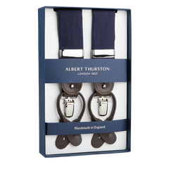 A pair of Albert Thurston Navy Linen and Brown Leather 35 mm Braces in a presentation box, featuring navy straps and leather fittings, with the text "Handmade in England.