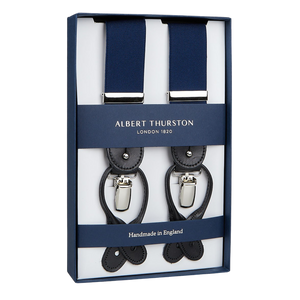 A pair of navy stretchable nylon Albert Thurston braces displayed in a box, indicating they are handmade in England.