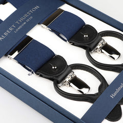 A close-up of Albert Thurston's Navy Nylon Black Leather 35 mm Braces in a box, featuring silver clips and black leather accents with navy stretchable nylon for an ideal fit.