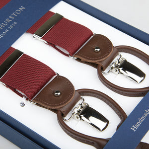 A pair of handmade Albert Thurston wine-red nylon elastic and brown leather braces displayed in an open box labeled "Albert Thurston, London 1820.