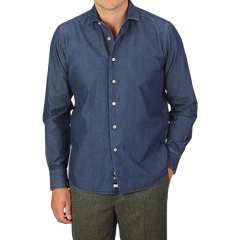 A person is wearing an Alessandro Gherardi Dark Blue Cotton Denim Single Cuff Shirt with brown trousers. The image is cropped at the neck and thighs.