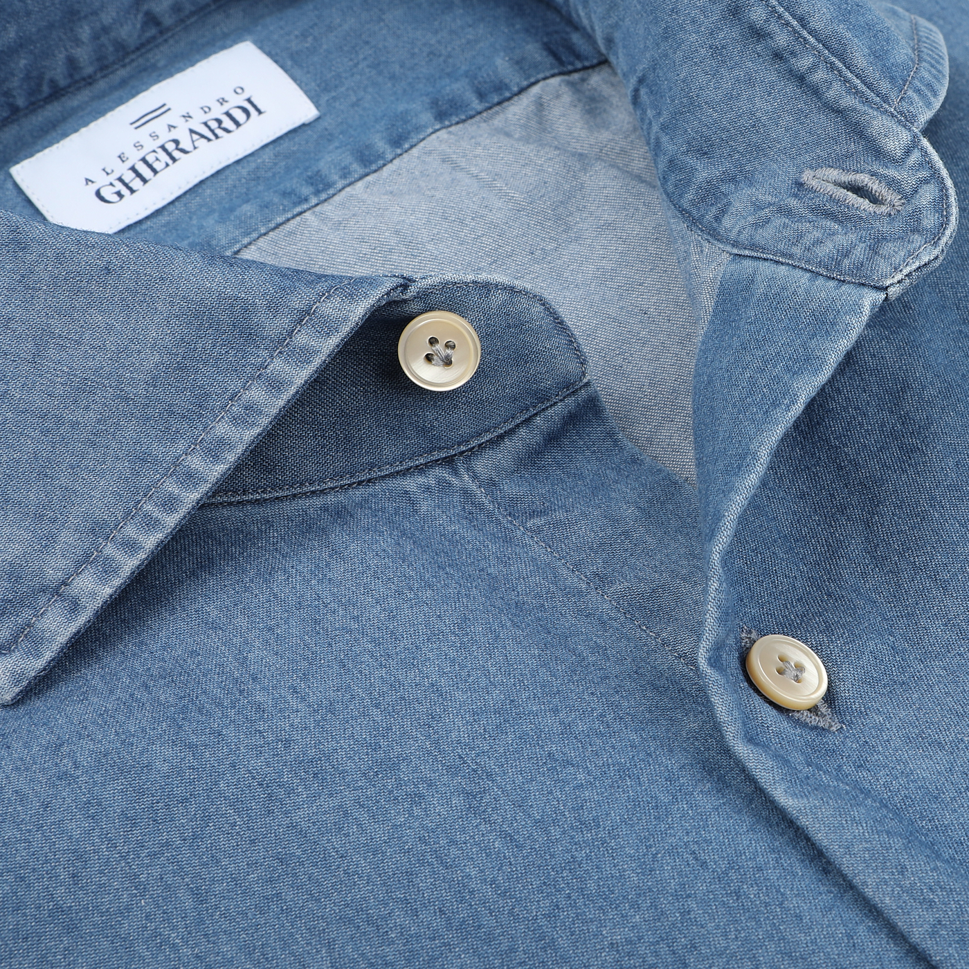 Close-up of a Light Blue Cotton Denim Single Cuff Shirt by Alessandro Gherardi, featuring two cream buttons fastened and a label that reads "ALESSANDRO GHERARDI.