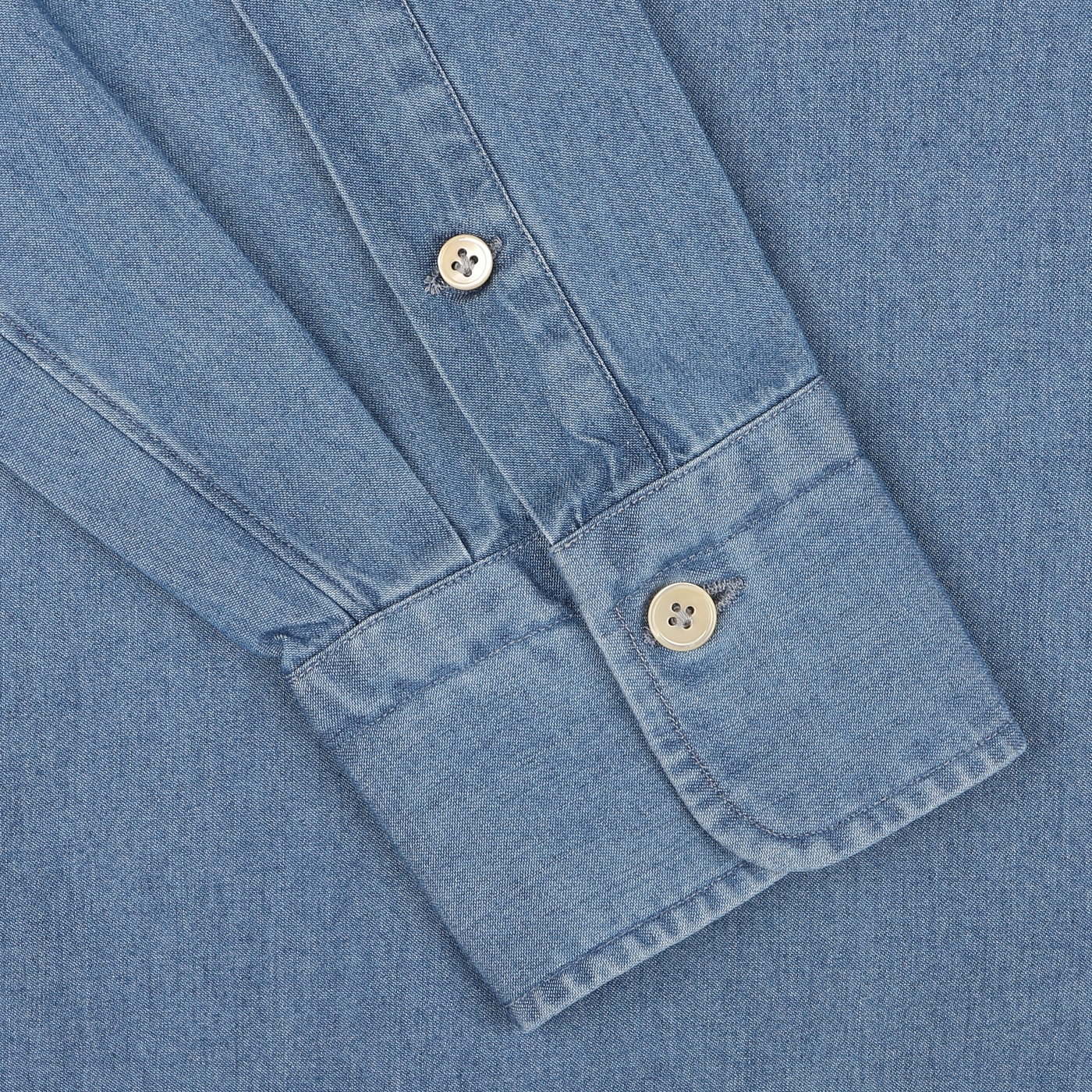 Close-up of the sleeve of Alessandro Gherardi's Light Blue Cotton Denim Single Cuff Shirt, featuring two white buttons on the cuff and highlighting the intricate stitching and fabric texture of this pure cotton shirt.