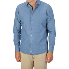 A person wearing an Alessandro Gherardi Light Blue Cotton Denim Single Cuff Shirt and beige pants stands against a plain background. Their head is not visible in the frame.