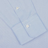 Close-up view of the cuff of an Alessandro Gherardi Light Blue Cotton Oxford Single Cuff Shirt, featuring two white buttons and crafted from pure cotton oxford, on a plain background.