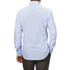 A man is shown from the back wearing an Alessandro Gherardi Light Blue Grid-Checked Cotton Single Cuff Shirt and brown pants against a plain background.