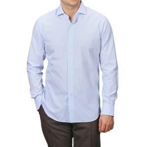 Someone wearing an Alessandro Gherardi light blue grid-checked cotton single cuff shirt with long sleeves and dark pants, standing neutrally.