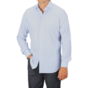 Person wearing an Alessandro Gherardi Light Blue Striped Cotton Single Cuff Shirt and dark pants, standing against a plain gray background.