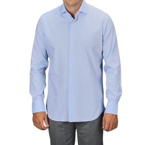 A person wearing an Alessandro Gherardi Sky Blue Cotton Twill Single Cuff Shirt and gray pants. The background is plain and not visible.