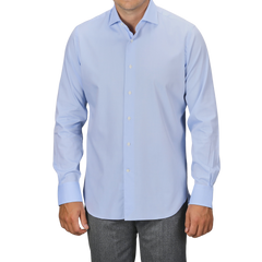 A person wearing an Alessandro Gherardi Sky Blue Cotton Twill Single Cuff Shirt and gray pants. The background is plain and not visible.