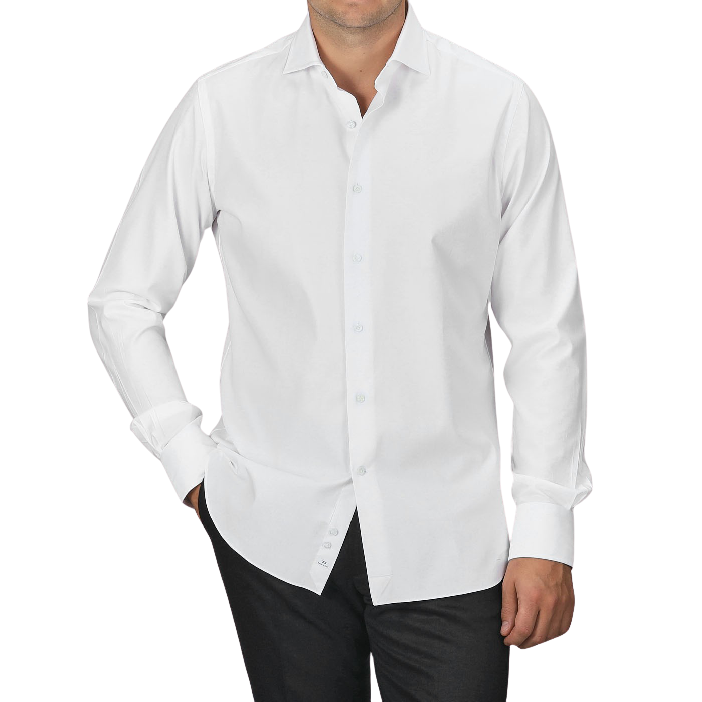 A man wearing an Alessandro Gherardi White Cotton Twill Single Cuff Shirt and black pants stands with his hands in his pockets against a plain gray background.