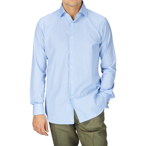 A man wearing a fitted cut, Alexander Kraft Monte Carlo Blue White Bengal Stripe Cotton Double Cuff Shirt and green pants.
