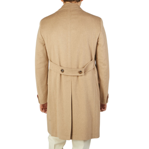 The back view of a man wearing an Alexander Kraft Monte Carlo Camel Beige Pure Cashmere Florence DB Overcoat.